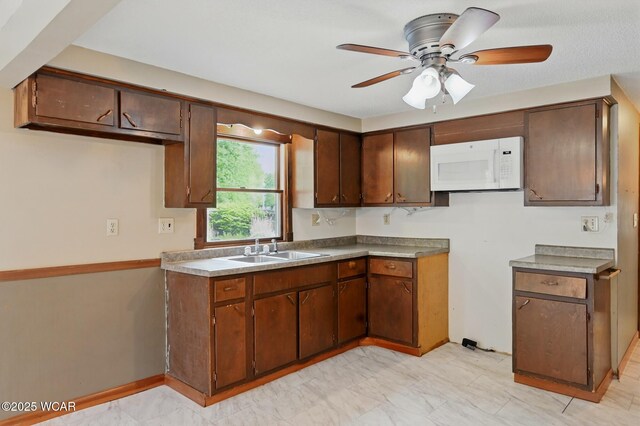 514 S Wayne St, Van Wert, OH 45891 - kitchen featuring white microwave, a sink, a ceiling fan, and light marble finish floors