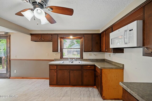 514 S Wayne St, Van Wert, OH 45891 - kitchen featuring white microwave, a sink, healthy amount of natural light, a ceiling fan, and a textured ceiling
