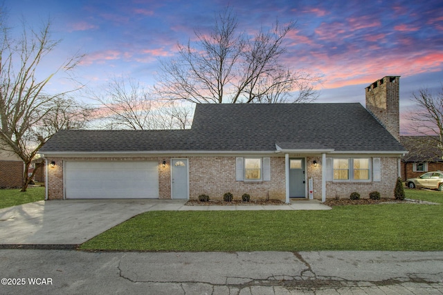 view of front of home featuring a garage and a yard