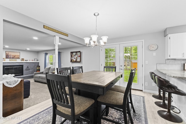 120 Barnsbury Dr, Lima, OH 45804 - dining space featuring light wood-style floors, a brick fireplace, a chandelier, french doors, and recessed lighting