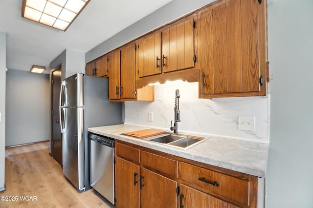 591 Monticello Ave Unit A, Lima, OH 45804 - kitchen with stainless steel dishwasher, backsplash, light countertops, brown cabinetry, and light wood-style floors