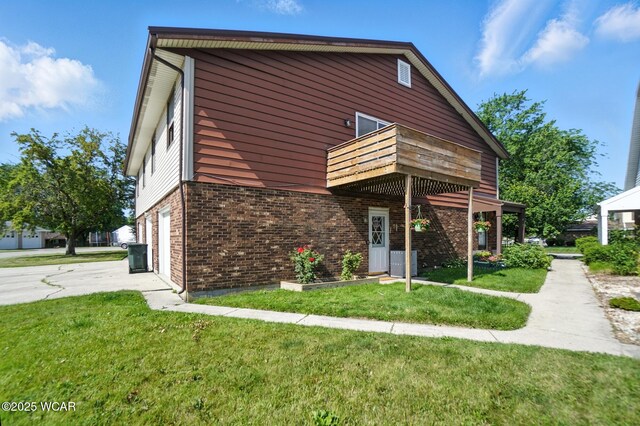 591 Monticello Ave Unit A, Lima, OH 45804 - view of front of property featuring a balcony, an attached garage, brick siding, and a front lawn