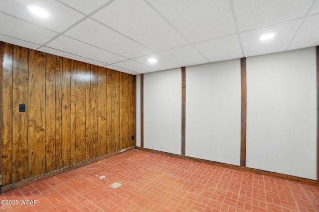 1257 Timberlane Dr, Lima, OH 45805 - unfurnished room featuring a paneled ceiling, wood walls, recessed lighting, brick patterned floors, and baseboards