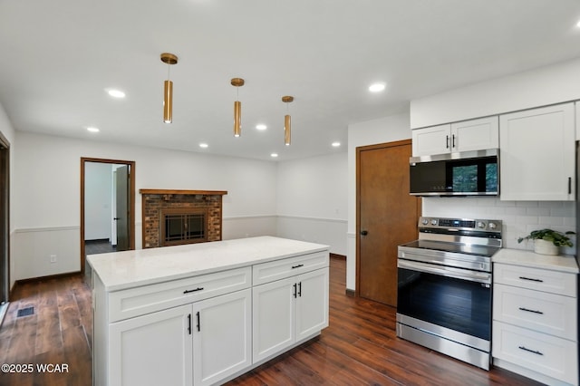 1257 Timberlane Dr, Lima, OH 45805 - kitchen featuring appliances with stainless steel finishes, dark wood-style flooring, recessed lighting, white cabinets, and tasteful backsplash