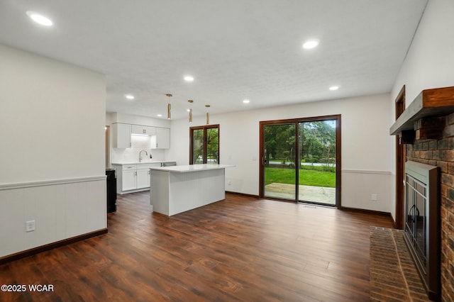1257 Timberlane Dr, Lima, OH 45805 - kitchen with a brick fireplace, a center island, light countertops, dark wood-style floors, and recessed lighting