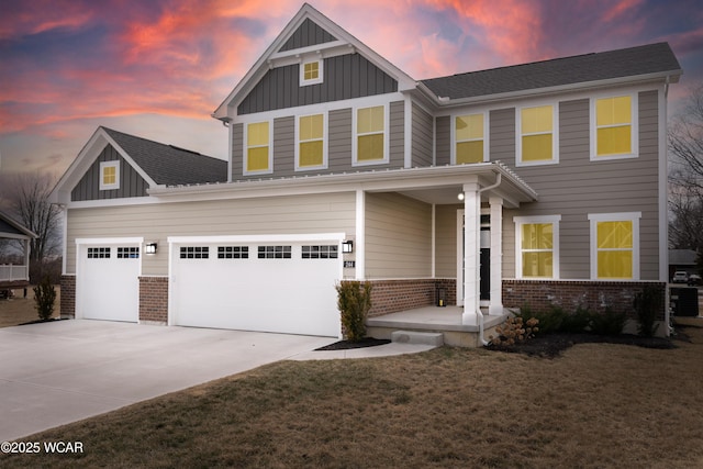 craftsman-style house with board and batten siding, a yard, brick siding, and driveway