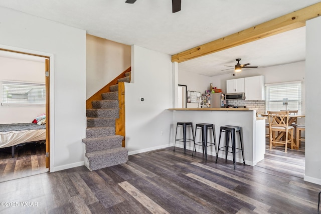 514 W Taylor St, Mount Victory, OH 43340 - kitchen with a ceiling fan, stainless steel appliances, a kitchen bar, dark wood-style floors, and beam ceiling