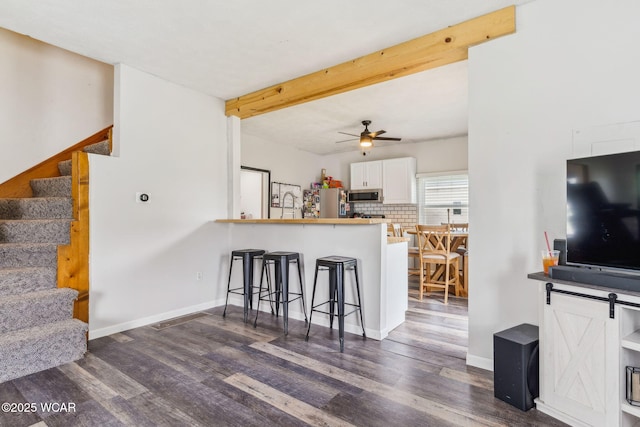 514 W Taylor St, Mount Victory, OH 43340 - kitchen featuring appliances with stainless steel finishes, a breakfast bar, dark wood-style floors, a ceiling fan, and white cabinets