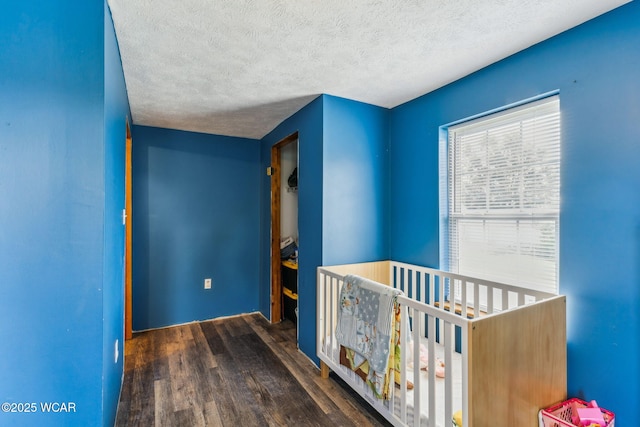 514 W Taylor St, Mount Victory, OH 43340 - bedroom with wood finished floors, a textured ceiling, and a crib