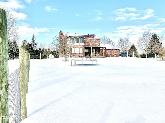 view of snow covered rear of property