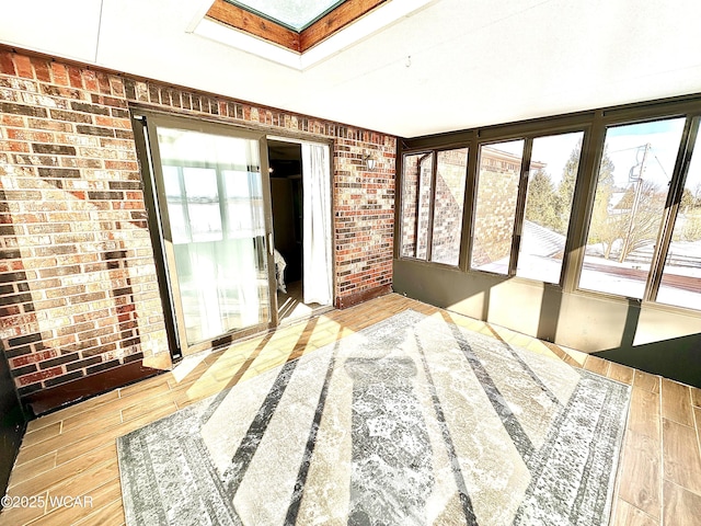 unfurnished sunroom featuring a skylight