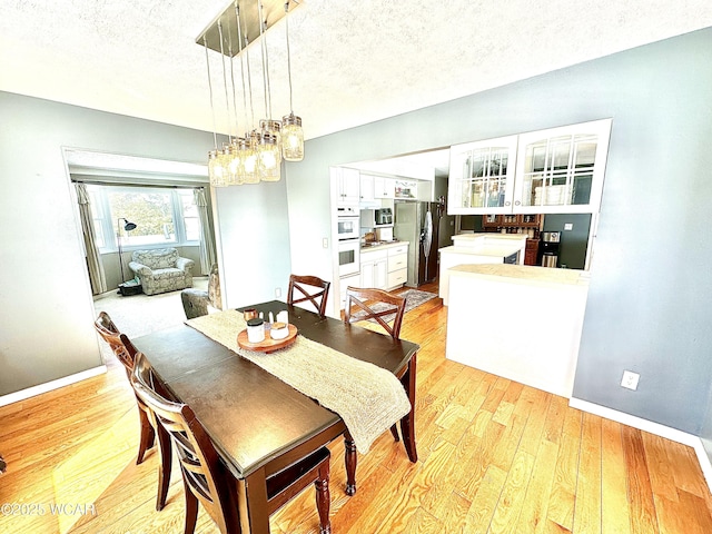 dining area featuring light hardwood / wood-style flooring and a textured ceiling