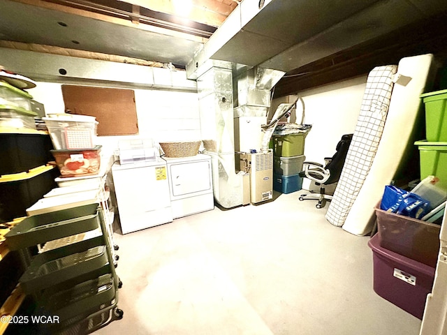 basement featuring heating unit and washer and clothes dryer