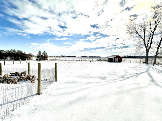 yard layered in snow featuring a shed