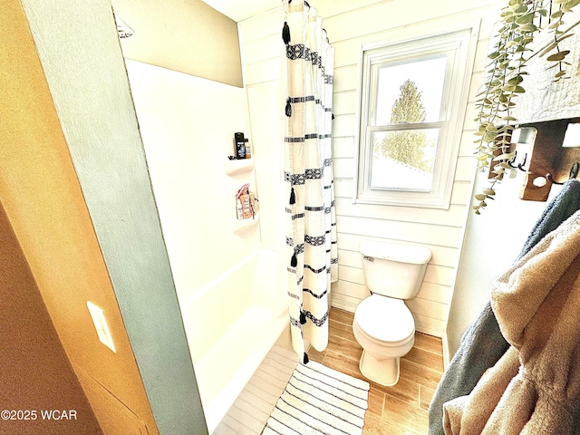 bathroom with hardwood / wood-style flooring, curtained shower, and toilet