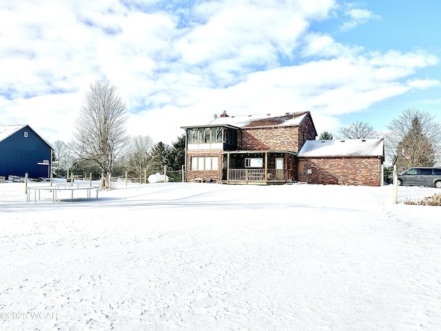 snow covered house with a sunroom