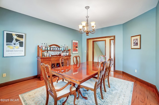 dining room with a chandelier and light hardwood / wood-style flooring