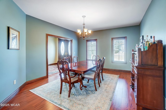 dining room featuring hardwood / wood-style floors, plenty of natural light, and a chandelier