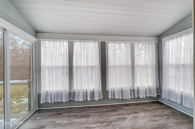 unfurnished sunroom featuring wood ceiling, plenty of natural light, and vaulted ceiling