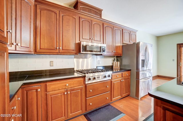 kitchen with decorative backsplash, light wood-type flooring, and appliances with stainless steel finishes