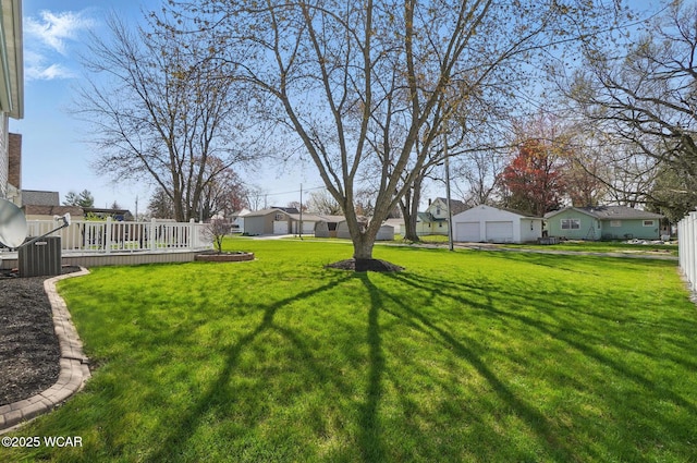 view of yard with a garage, a residential view, and a wooden deck