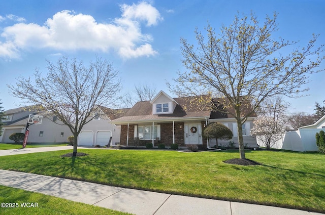 view of front of property featuring fence, driveway, a front lawn, and brick siding
