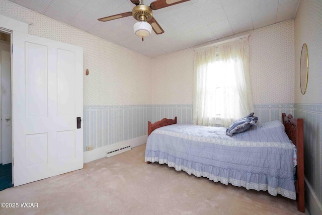 315 W Main St, Cairo, OH 45820 - bedroom featuring wallpapered walls, carpet flooring, a wainscoted wall, a baseboard heating unit, and ceiling fan