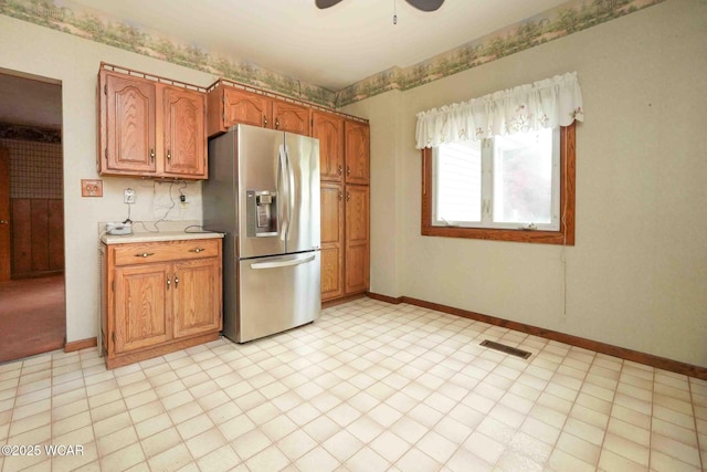 315 W Main St, Cairo, OH 45820 - kitchen featuring stainless steel fridge, light countertops, ceiling fan, brown cabinets, and baseboards