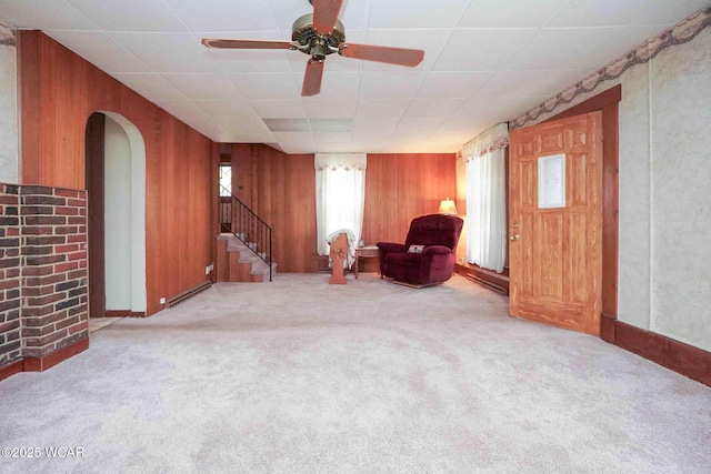 315 W Main St, Cairo, OH 45820 - unfurnished room with stairs, wood walls, carpet flooring, a ceiling fan, and arched walkways