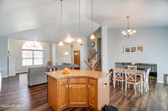 kitchen featuring a kitchen island, lofted ceiling, dark wood-type flooring, open floor plan, and a chandelier