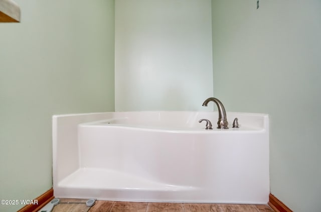 full bathroom featuring baseboards and a tub to relax in