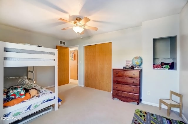 bedroom featuring a ceiling fan, visible vents, carpet floors, baseboards, and a closet