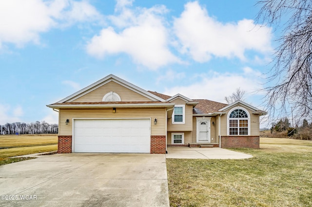 split level home featuring a front yard, an attached garage, brick siding, and driveway
