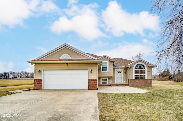 split level home featuring a front yard, a garage, brick siding, and driveway