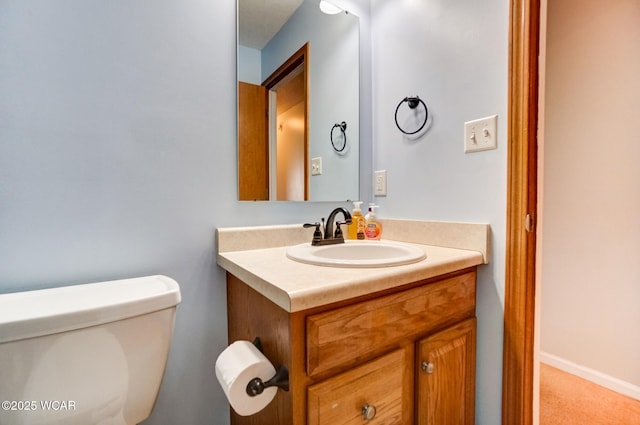 bathroom featuring vanity, toilet, and baseboards