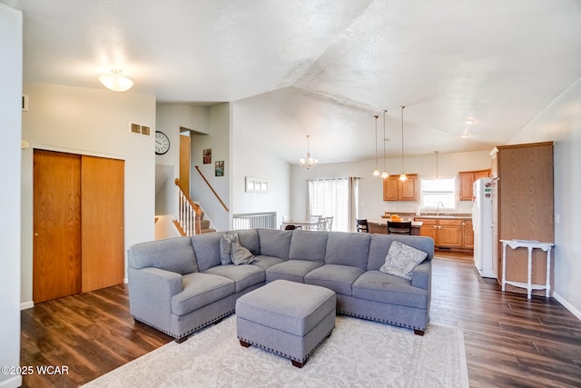 living room featuring visible vents, stairway, dark wood-type flooring, and lofted ceiling