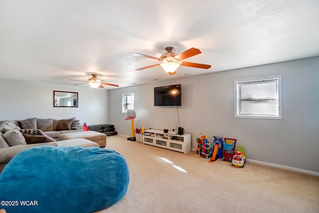 carpeted living room with a textured ceiling, baseboards, and ceiling fan