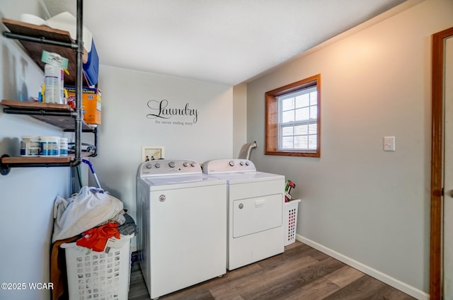 washroom featuring washing machine and clothes dryer, laundry area, baseboards, and wood finished floors