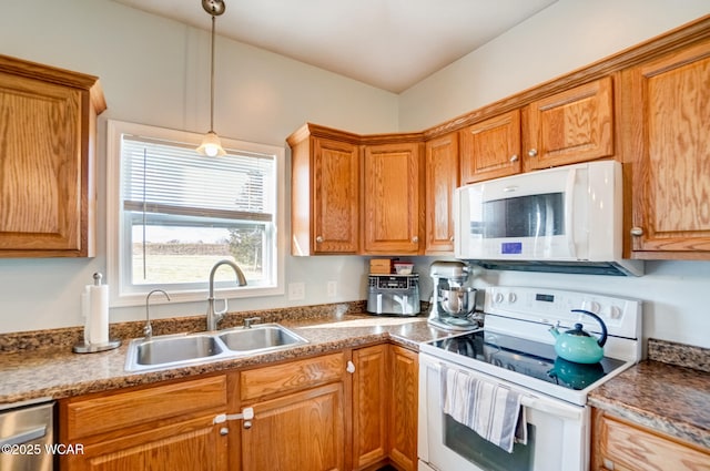 kitchen with hanging light fixtures, white appliances, brown cabinetry, and a sink