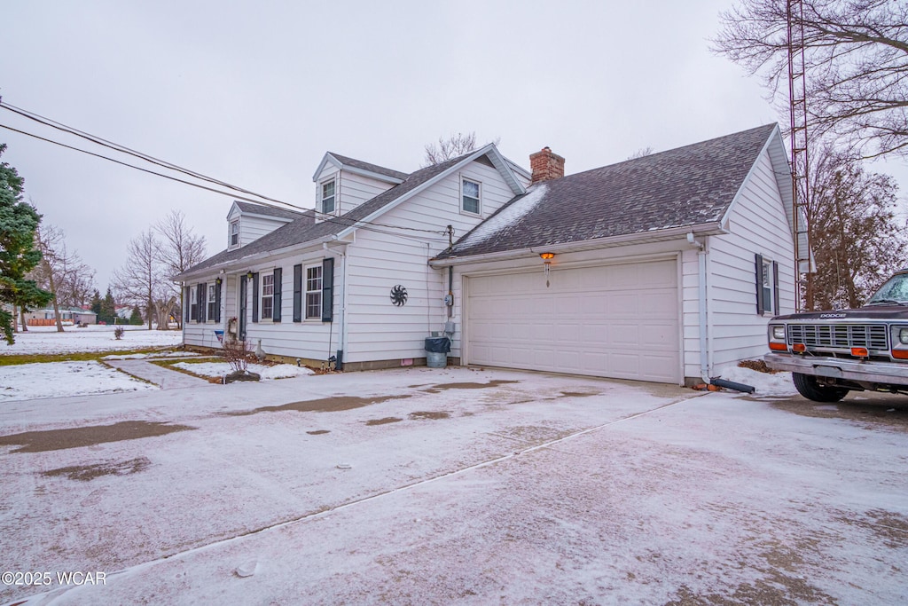 snow covered property with a garage