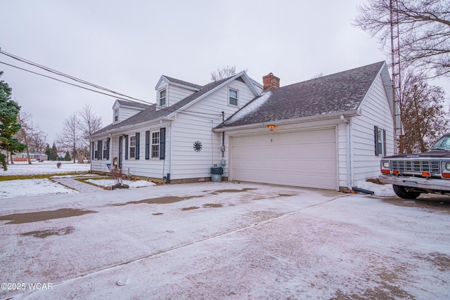 snow covered property with a garage