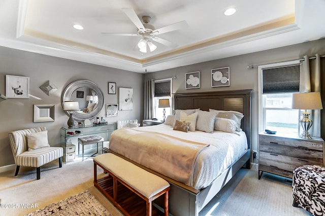 carpeted bedroom featuring a tray ceiling and ceiling fan