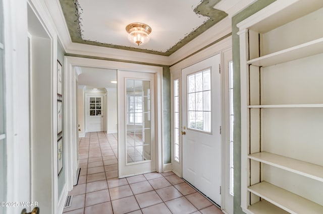 tiled entryway featuring crown molding