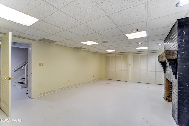 basement with a fireplace and a drop ceiling