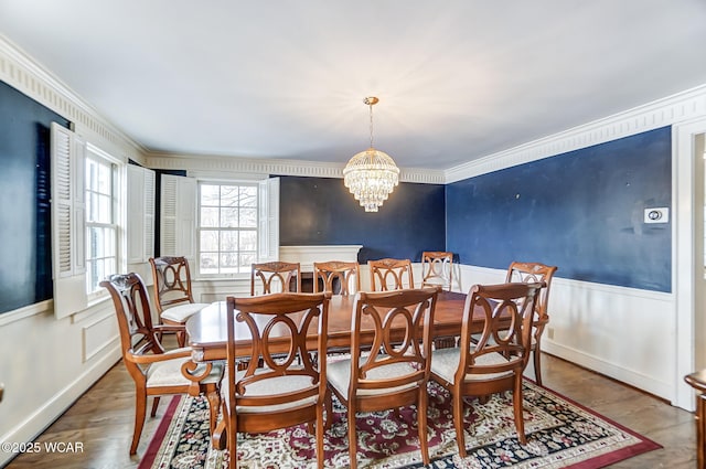 dining space with crown molding, an inviting chandelier, and hardwood / wood-style floors