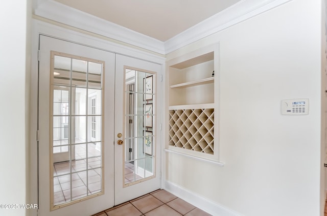 doorway to outside featuring light tile patterned floors, ornamental molding, and french doors