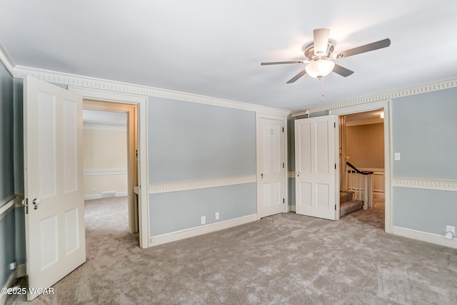 unfurnished room featuring ornamental molding, light colored carpet, and ceiling fan