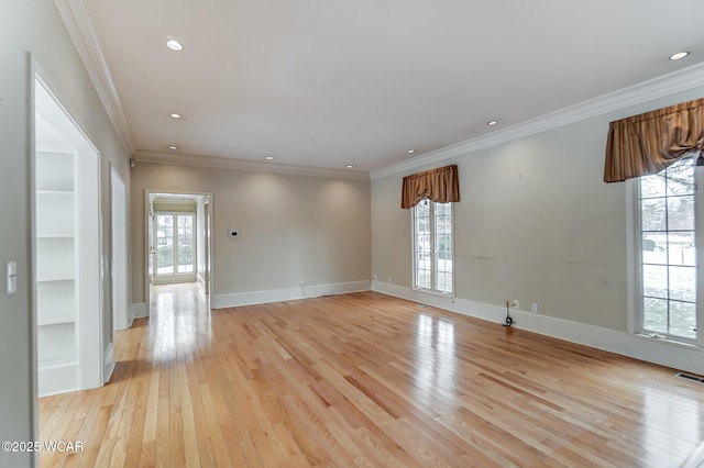 spare room featuring crown molding, light hardwood / wood-style floors, and a healthy amount of sunlight