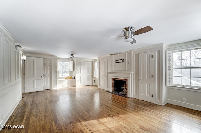 unfurnished living room with a healthy amount of sunlight, ceiling fan, and light wood-type flooring