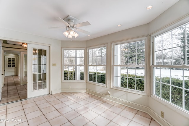 unfurnished sunroom with ceiling fan and a healthy amount of sunlight